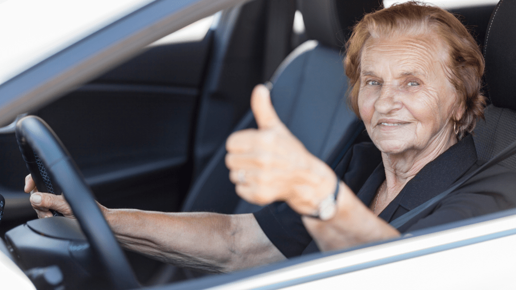 Femme âgée souriante conduisant sa voiture  permis de conduire seniors